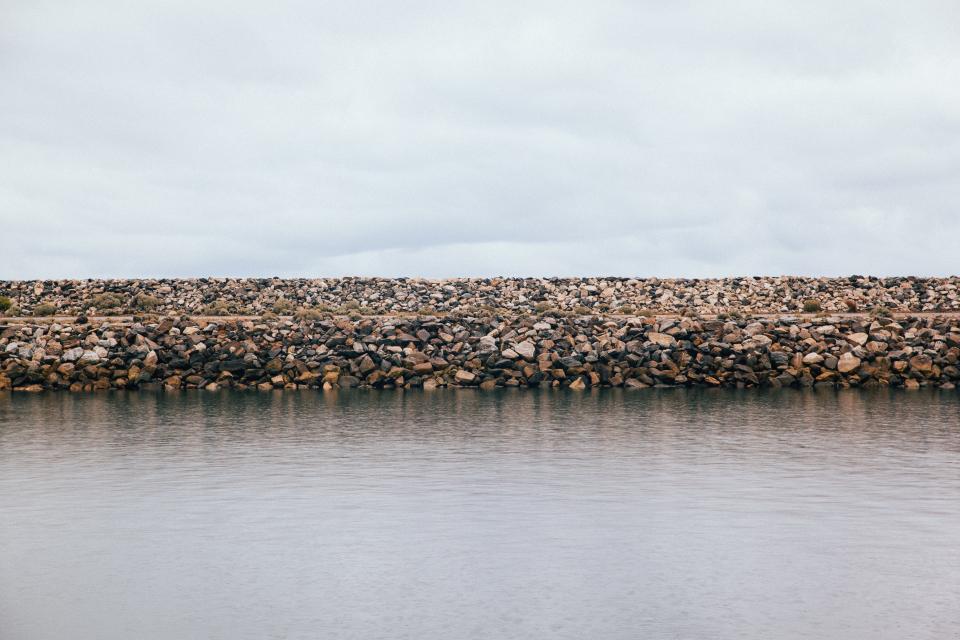 water stones sky rocks ocean grey clouds beach 